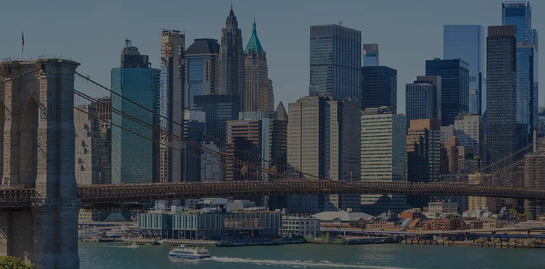 Panoramic view of New York City skyline with Brooklyn Bridge and East River boat.