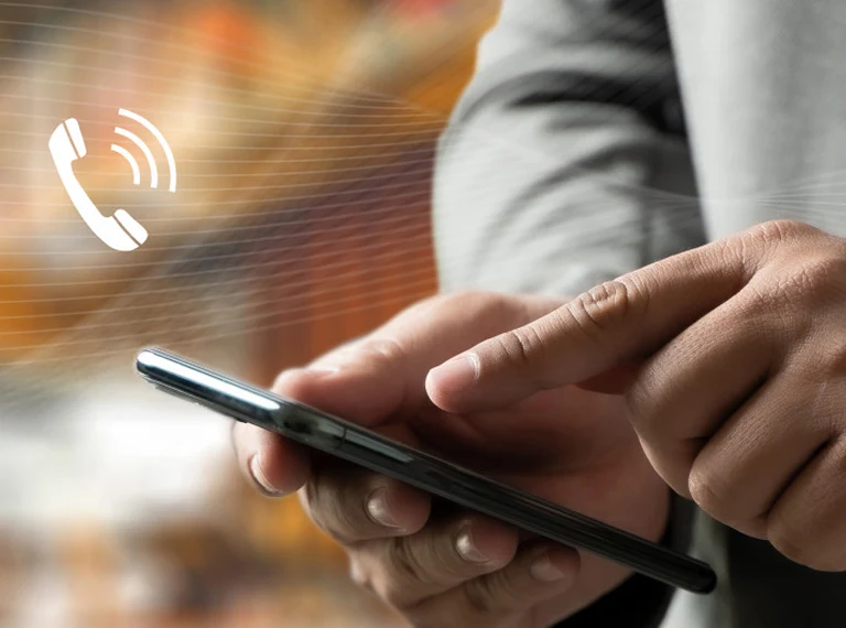 Close-up of a person using a smartphone with a white phone call icon overlay.