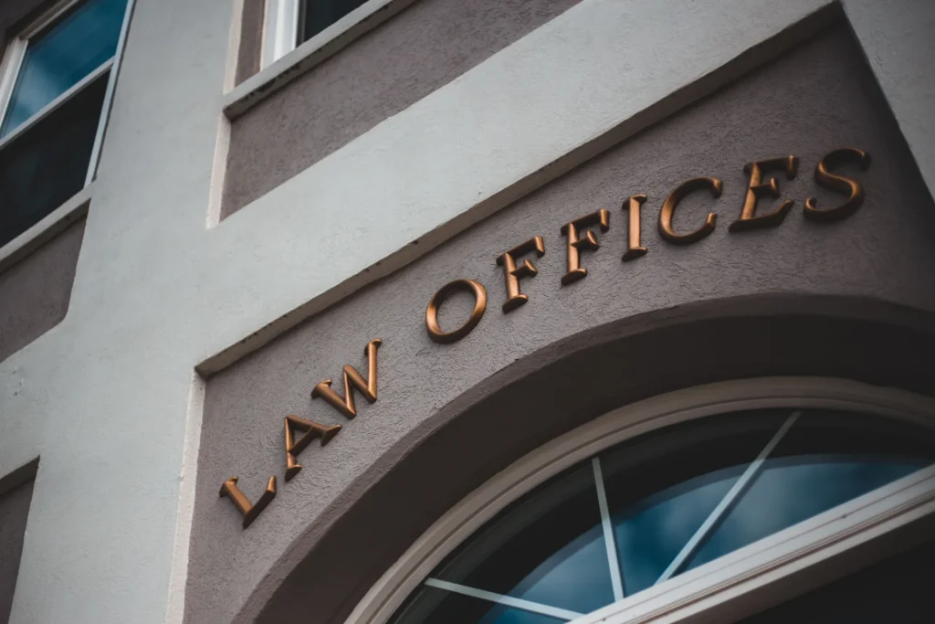 Close-up of a building facade with bronze "LAW OFFICES" letters above an arched window.